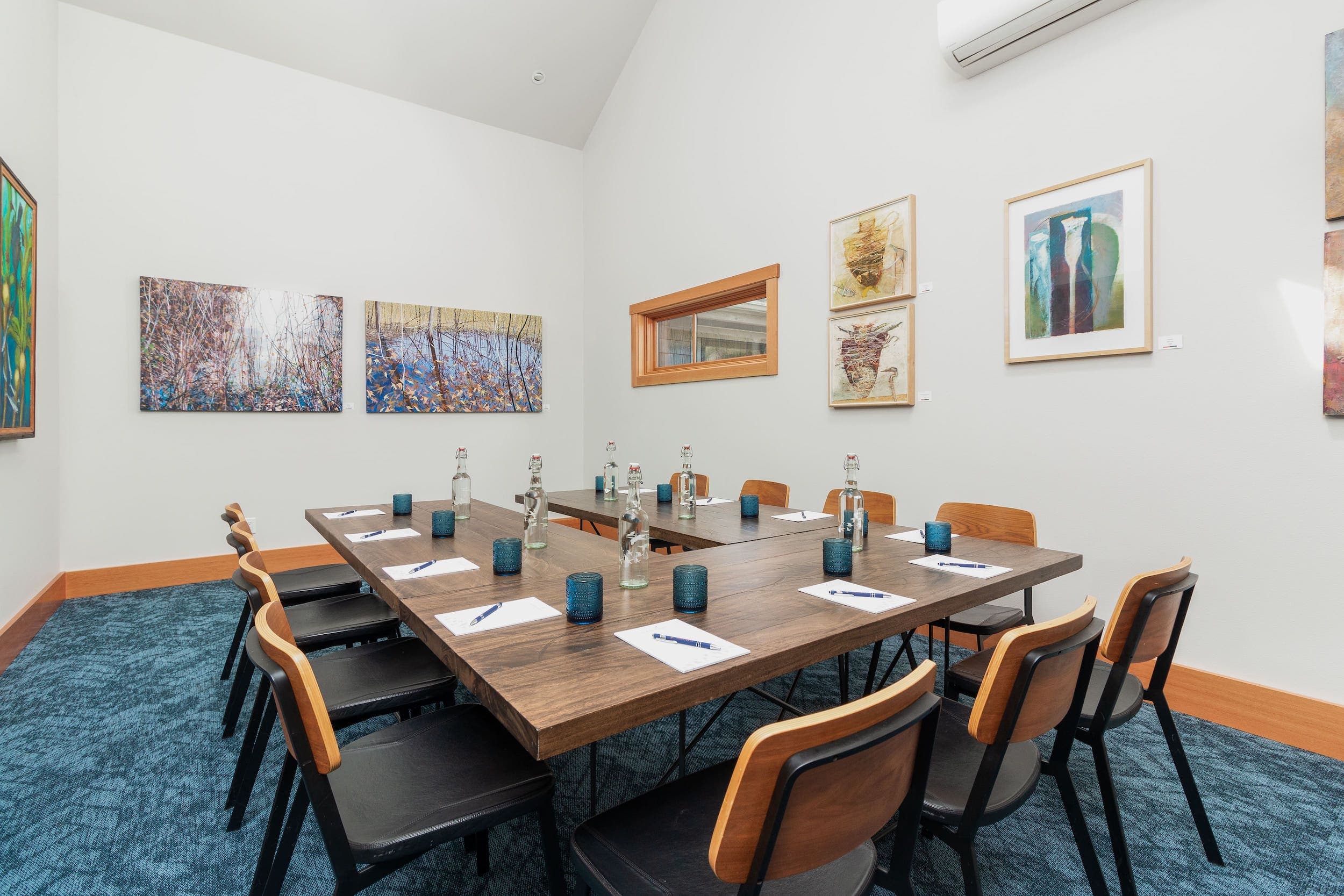 A meeting space with a horseshoe table setup that seats 11