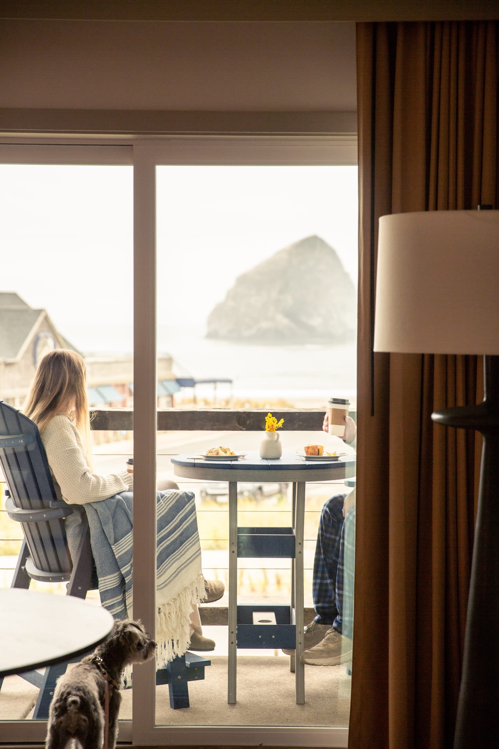 Two people sitting on the balcony to their room with a Stimulus coffees and snacks