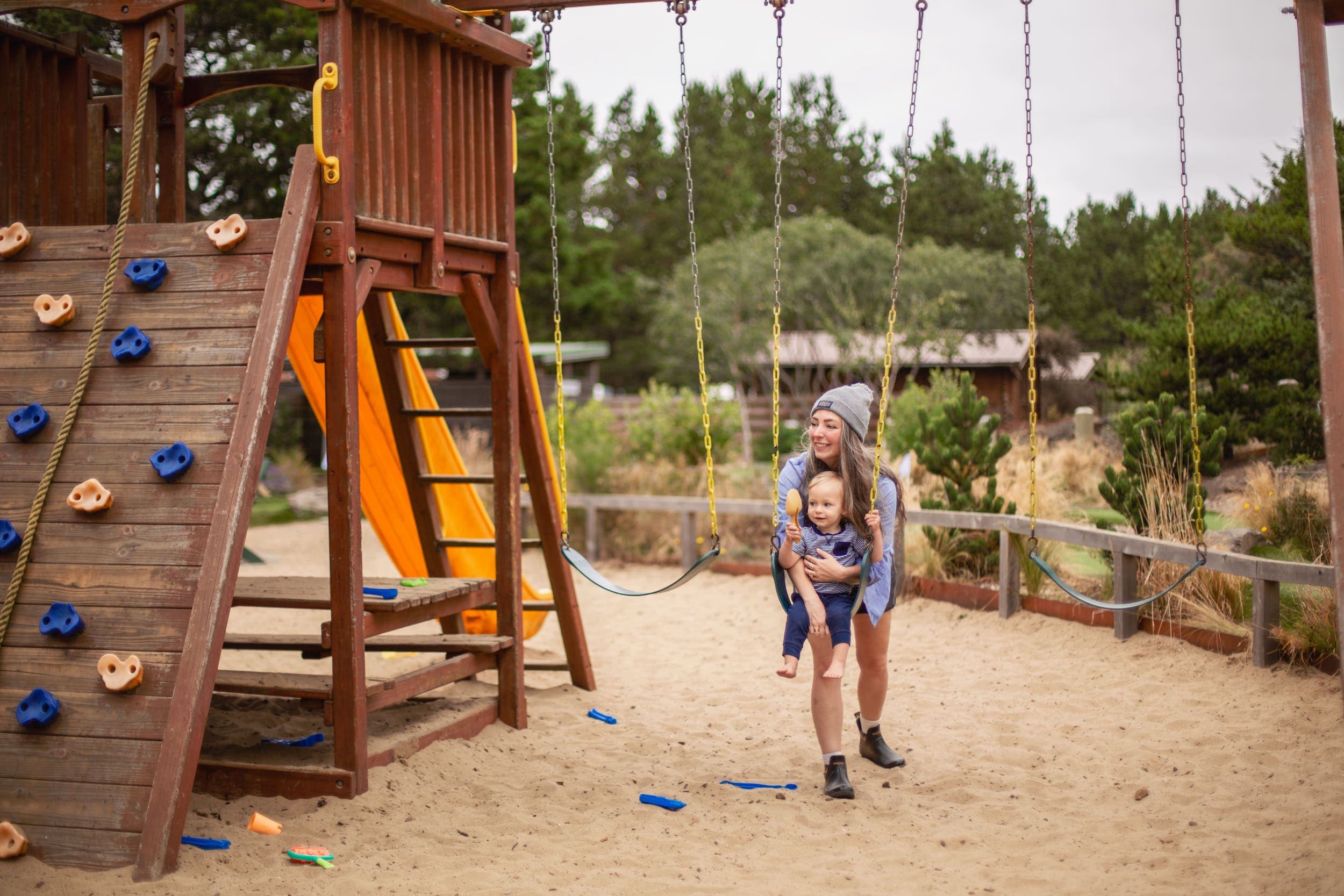 A mother swinging her child on a swing wet near Inn at Cape Kiwanda