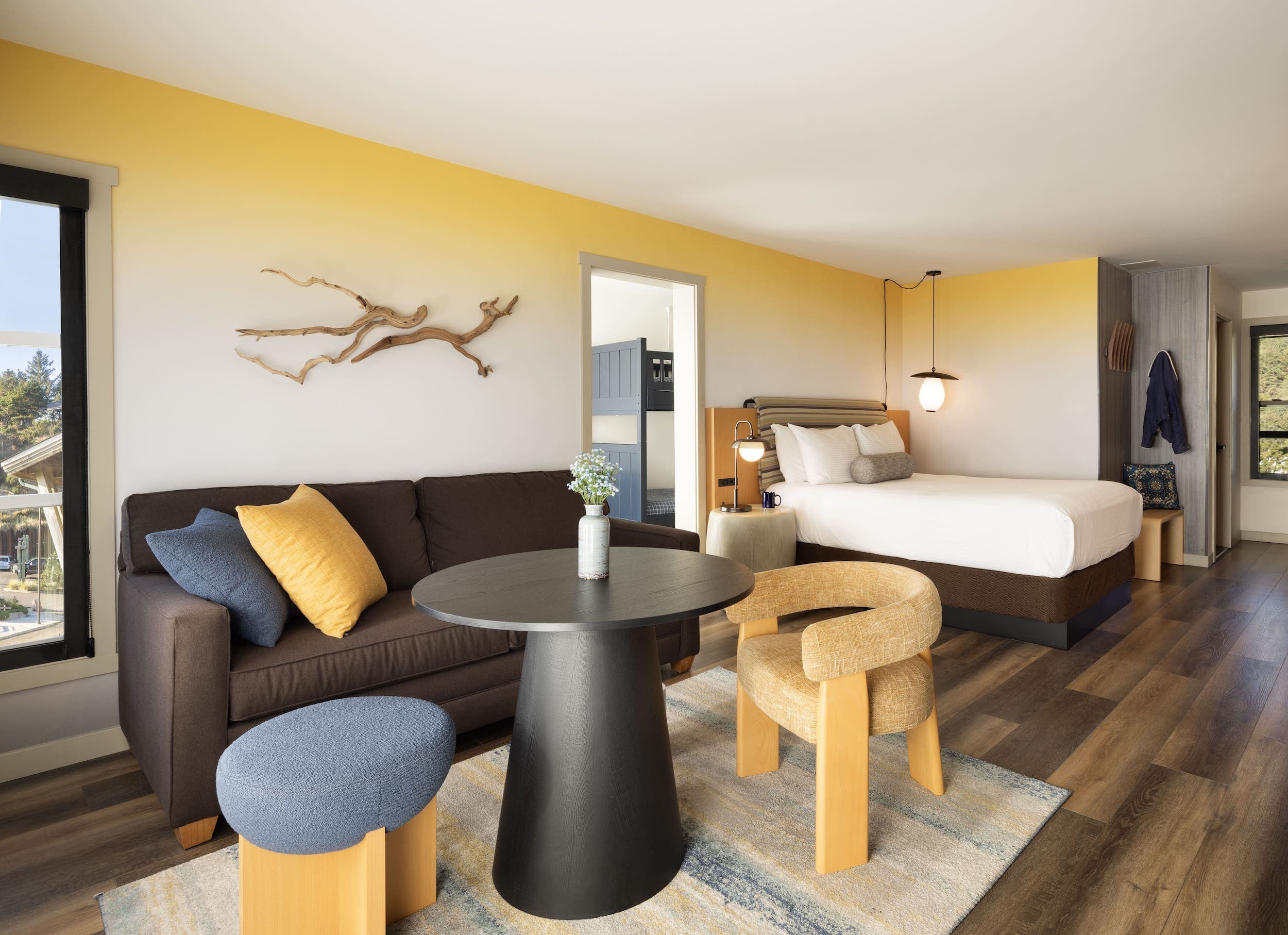 Inn At Cape Kiwanda Family Suite With Bunk Room living space and bed with a couch, round table with 2 chairs