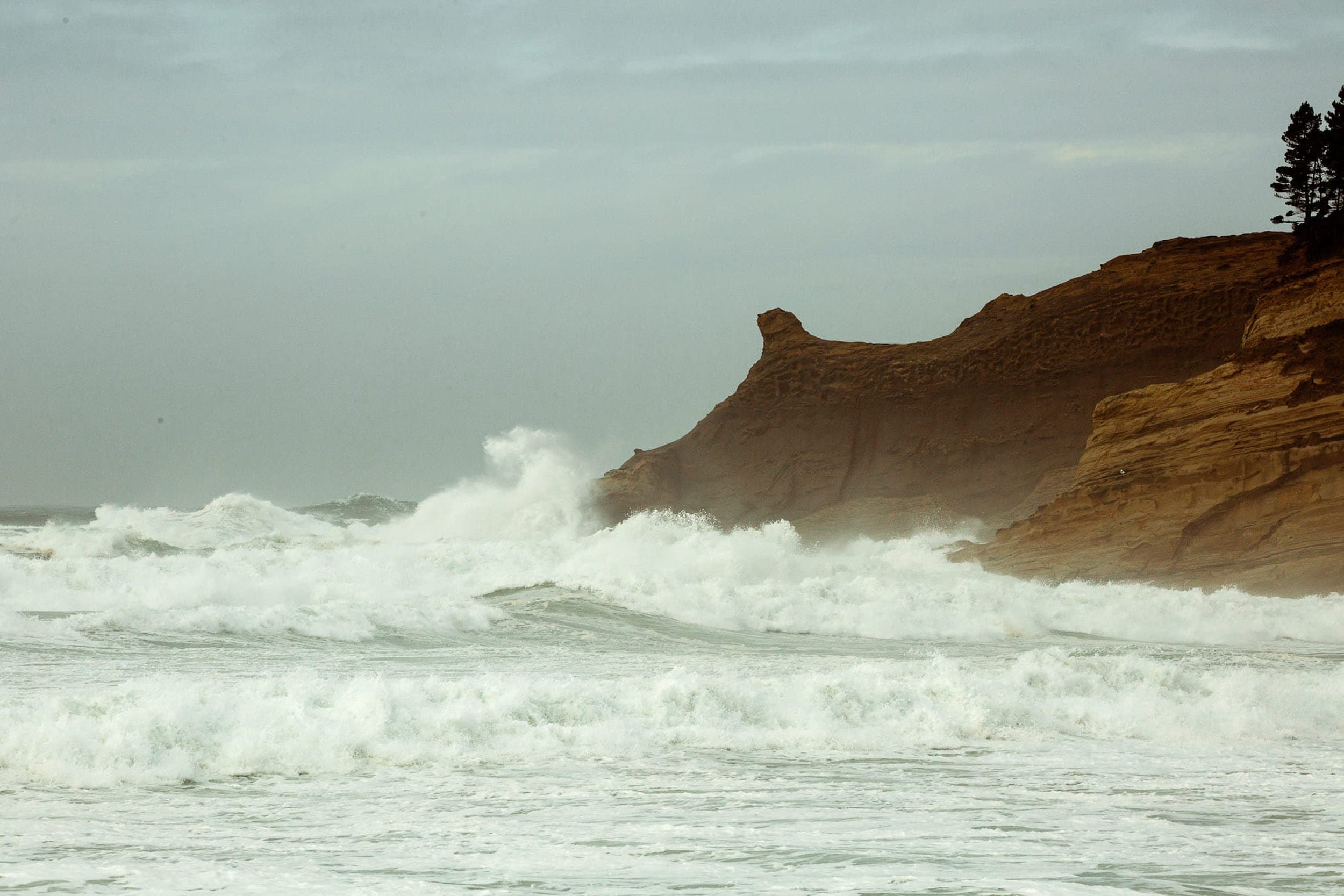 View of large waves hitting the side of the shore at King Tides on a foggy day