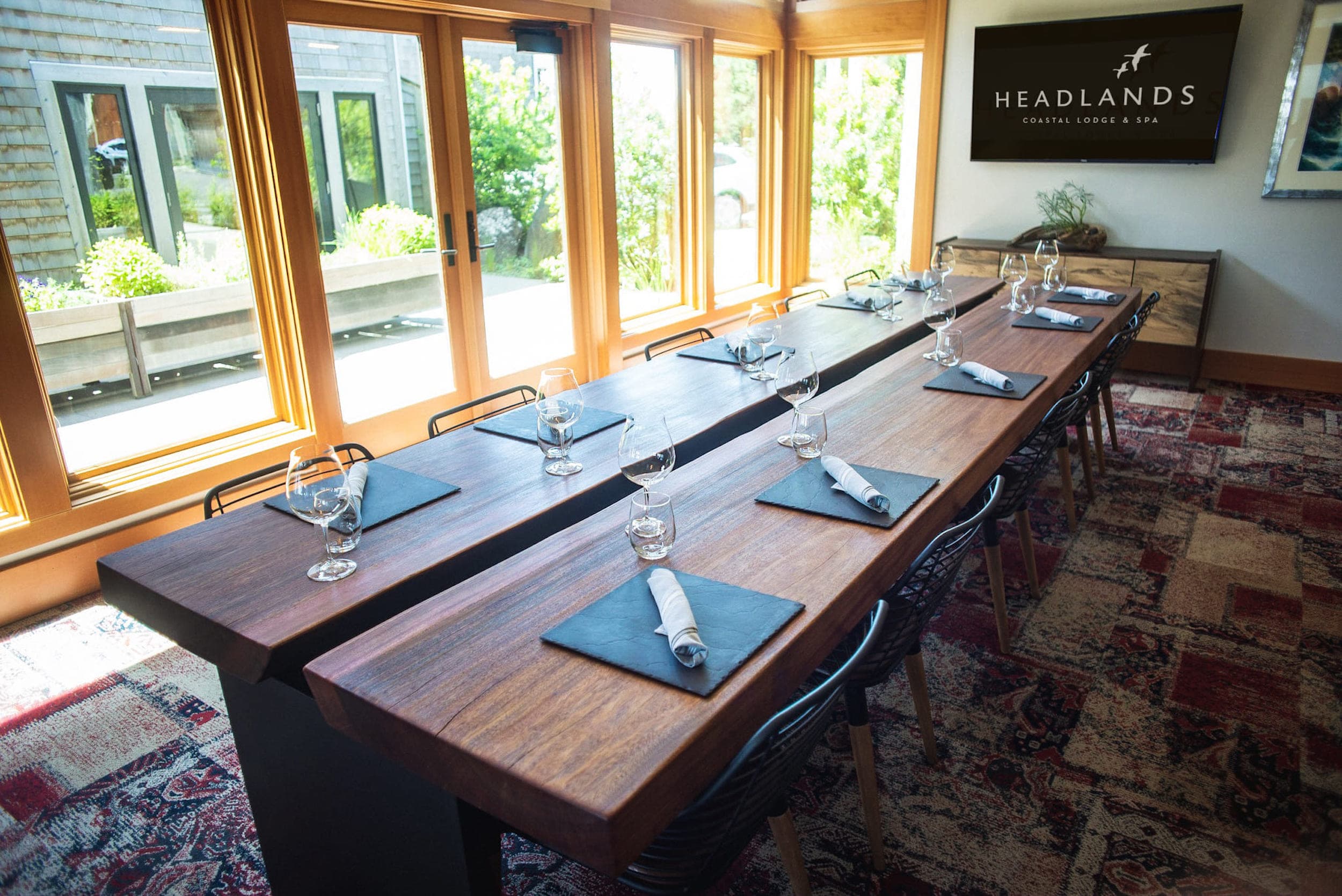 A meeting room at Headland Coastal Lodge & Spa with a wooden table and 10 seats set up for a meeting