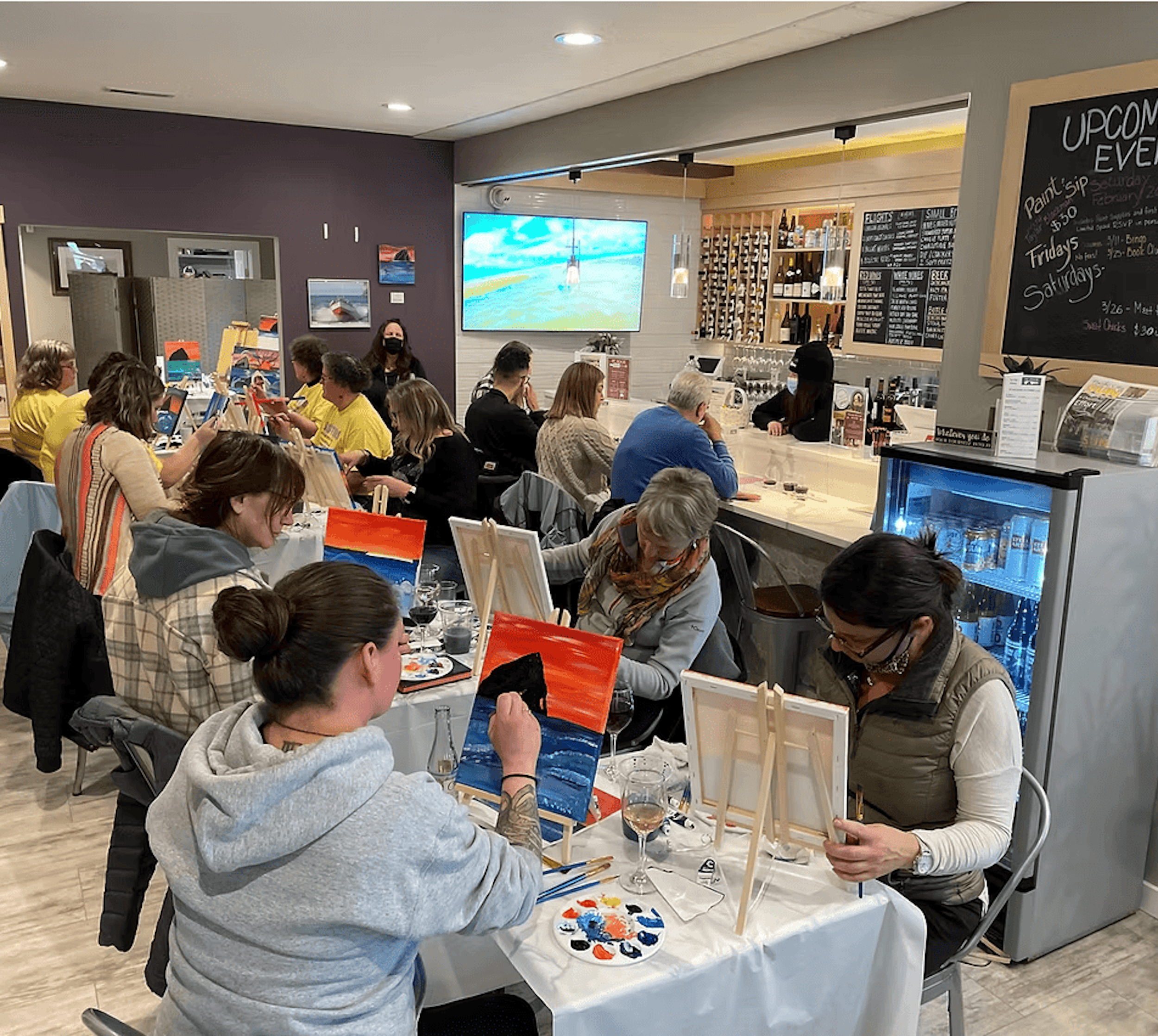 A PC Pour Wine Bar Event where people are tasting wine and painting