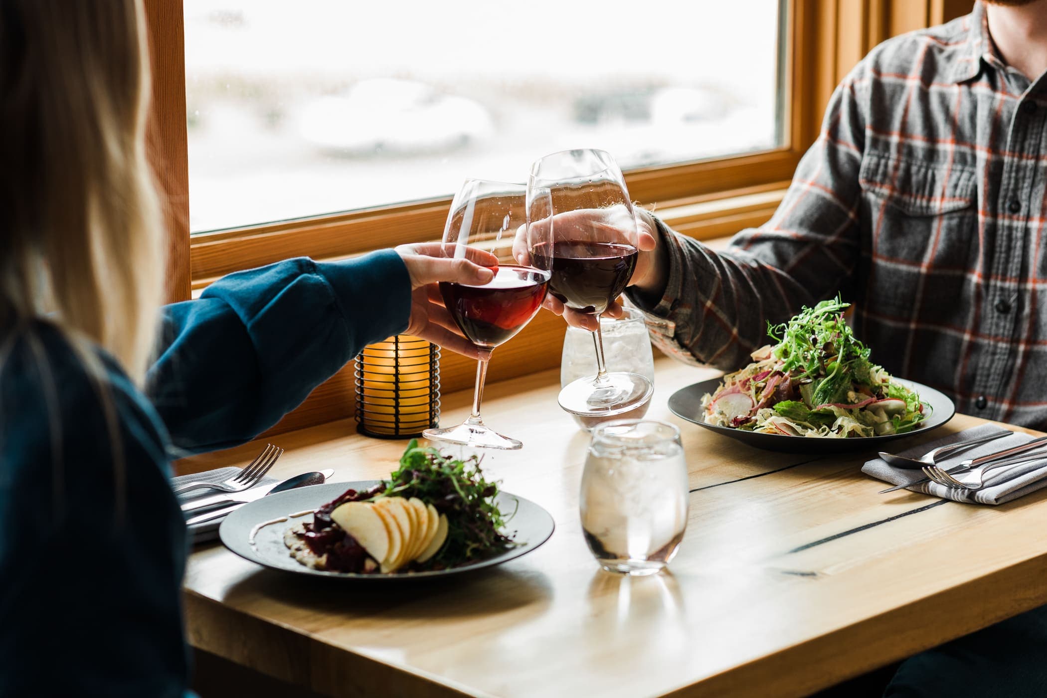 A couple eating dinner and having a glass of red wine at Coastal Chords & Corks event